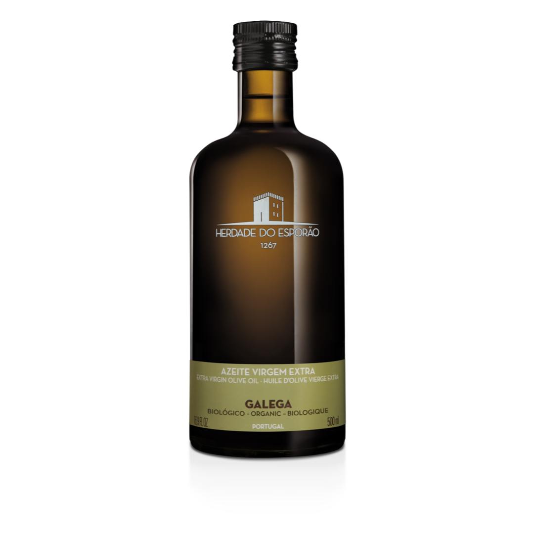 A bottle of Herdade do Esporão organic virgin olive oil with a label indicating it is Galega variety. The bottle is dark tinted with a black cap, and the label is primarily in white and green colors.